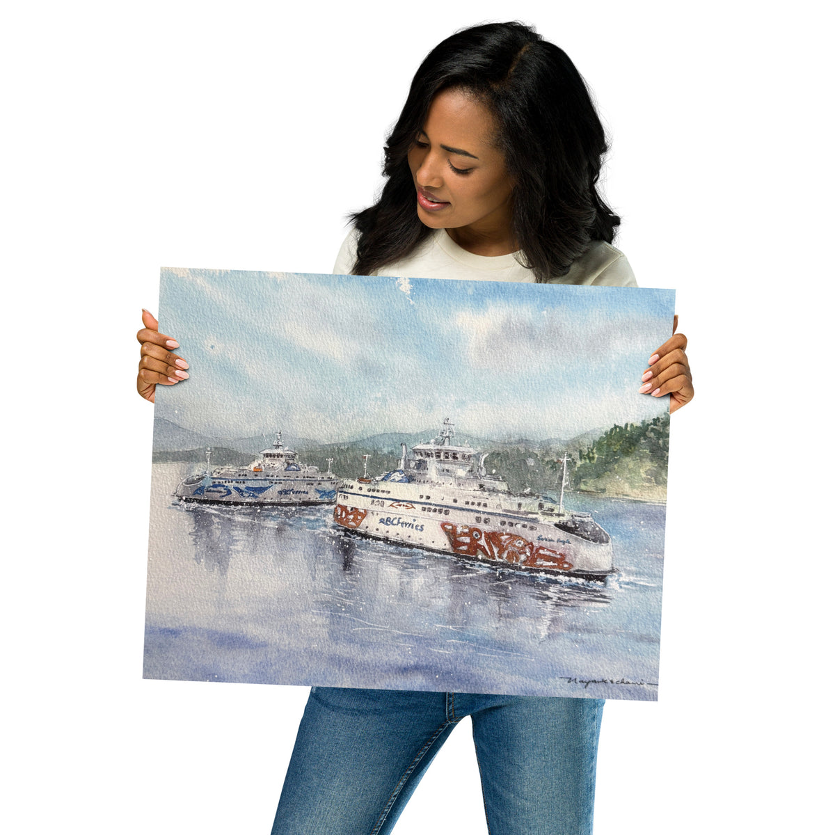 Model in a light top holding the unframed Salish Eagle & Salish Raven in Active Pass print at an angle; Salish Eagle and Salish Raven passing in Active Pass on reflective blue water, with forested shoreline, soft mountains and a pale coastal sky.