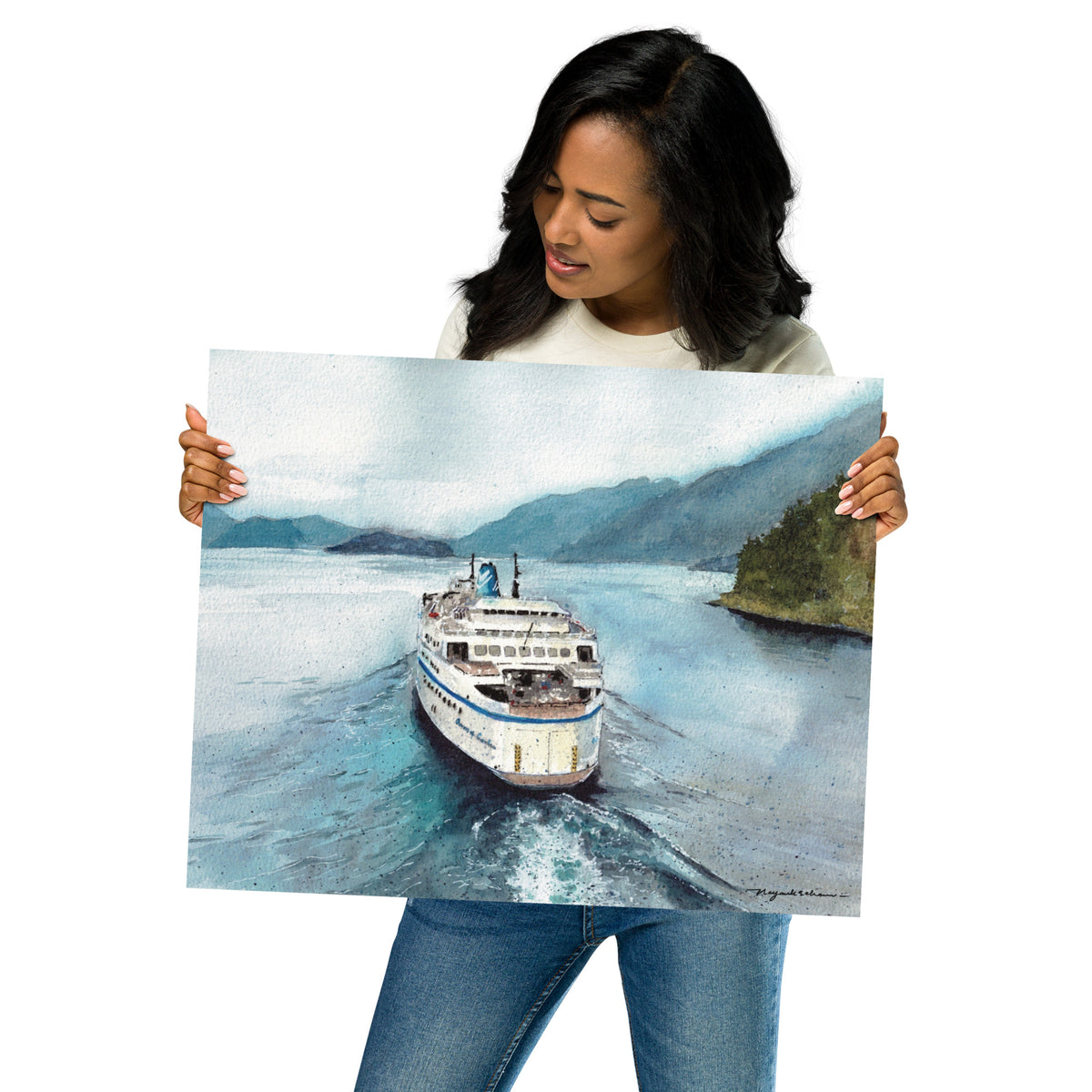 Model in a light top holding the unframed Queen of Cowichan Departing Horseshoe Bay print at an angle; stern view of Queen of Cowichan departing Horseshoe Bay through calm blue and turquoise water, leaving a bright wake between forested shoreline and misty coastal mountains.