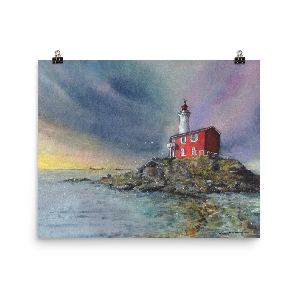 Fisgard Lighthouse watercolor print displayed with two black binder clips against a white background; Fisgard Lighthouse on a rocky shoreline beneath a dramatic blue, violet and yellow sky, with the red keeper's house reflected in calm coastal water.